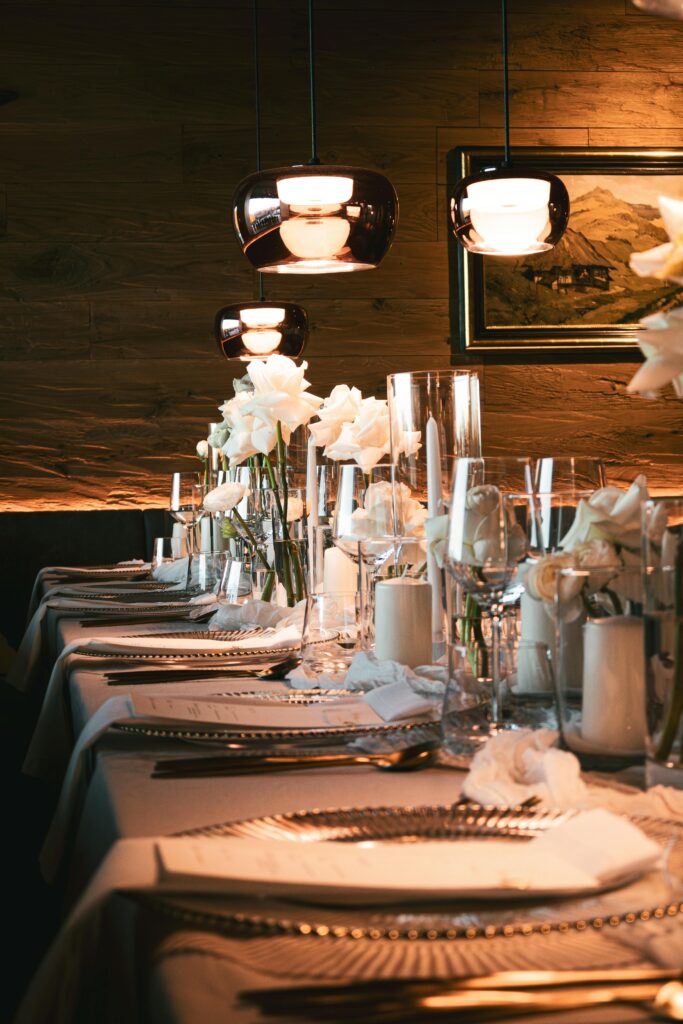 Chic table setting with white roses and soft lighting, perfect for weddings and elegant events.